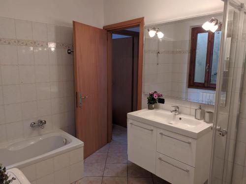 a bathroom with a tub and a sink and a tub and a mirror at SWEET VIEW in Varenna