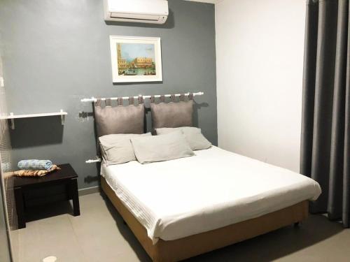 ein Schlafzimmer mit einem Bett mit einer weißen Tagesdecke in der Unterkunft HOTEL SHAFURA 2 in Cukai