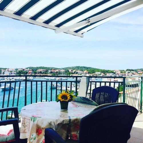 a table on a balcony with a view of the water at House Klarin in Jezera