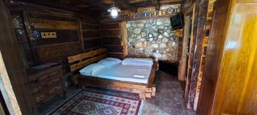 a bedroom with a bed in a wooden cabin at Satul Traditional in Runcu