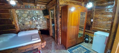 a bedroom with a bed in a wooden cabin at Satul Traditional in Runcu