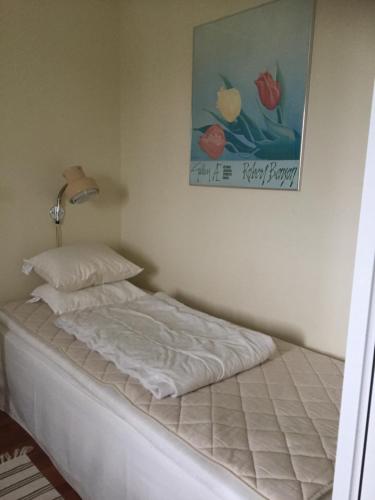 a white bed in a bedroom with a picture on the wall at Takvåning-Borgholm in Borgholm