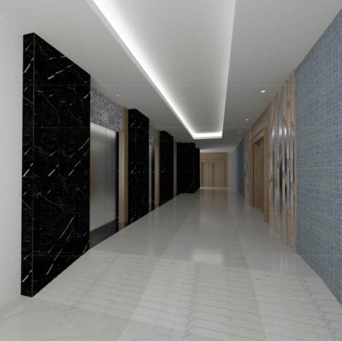 a hallway with black tile walls and a hallway with a hallwayngth at Aston Kemayoran City Hotel in Jakarta