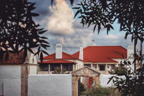 a house with a red roof and a white fence at Quinta do Regalo in Coimbra