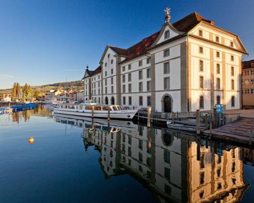 Hotel Mozart في رورشاخ: مبنى كبير بجانب الماء وفيه قارب