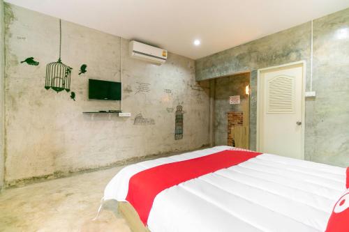 een slaapkamer met een bed met een rode en witte deken bij OYO 945 The Rome Resort in Pran Buri