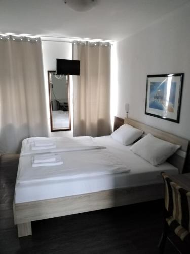 a bedroom with a large white bed and a mirror at Hotel Berliner Hof in Düsseldorf