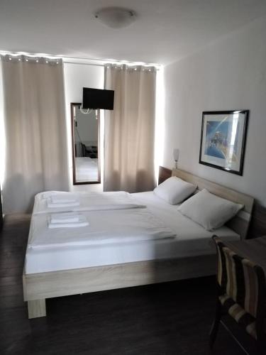 a large white bed in a bedroom with a mirror at Hotel Berliner Hof in Düsseldorf