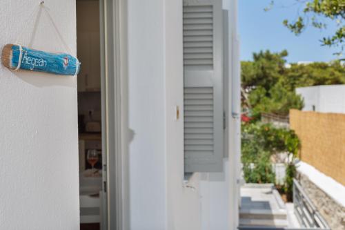 una porta che si apre su un balcone con una bottiglia di Heart of Paros Apartments a Kampos Paros