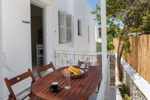 un tavolo in legno con un cesto di frutta sul balcone di Heart of Paros Apartments a Kampos Paros