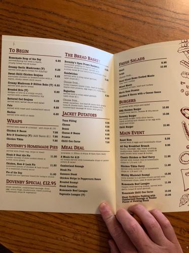 a person is holding a menu in their hand at DOVENBY SHIP in Tallentire