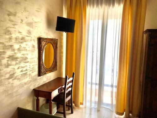 a dining room table with a mirror and a window at Bed & Breakfast Delle Palme in Trapani