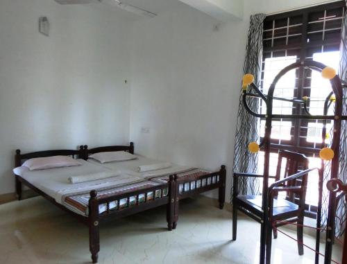 ein Schlafzimmer mit einem Bett und einem Stuhl in einem Zimmer in der Unterkunft Immanuel Home Stay in Kochi