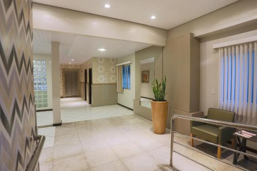 an office lobby with a waiting area with a plant at Hotel Veneza in Brusque