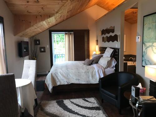 a bedroom with a bed and a large window at Domaine de la Baie, Les Suites in Shawinigan