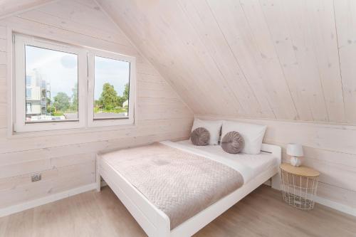 Habitación blanca con cama y ventana en Domki Oliwia en Sianozety