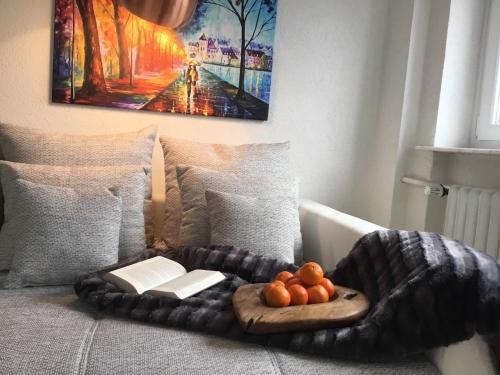 a bed with a blanket and a tray of fruit on it at Hotel Zum Berggarten in Kassel