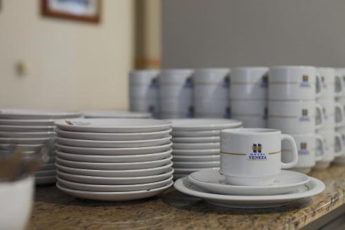 a pile of plates and cups on a counter at Hotel Veneza in Brusque