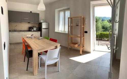 a kitchen with a wooden table and some chairs at Casa Mìtìlà in Bardolino