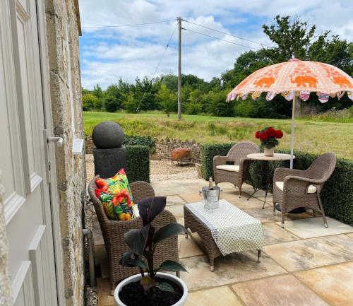 a patio with a table and chairs and an umbrella at The Old Flour Mill in Broadway