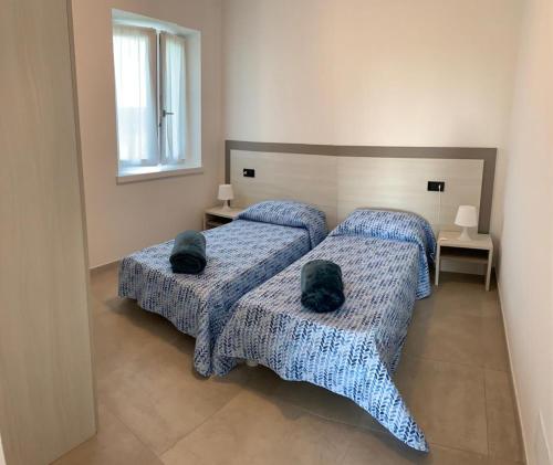 una camera con due letti con cuscini sopra di Casa Mìtìlà a Bardolino