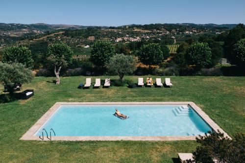 a person swimming in a swimming pool in a field at Hotel Rural Casa dos Viscondes da Varzea in Lamego