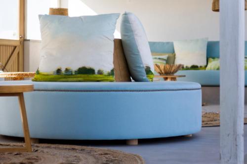 a blue couch with pillows on it in a living room at Hortas do Rio - Casa de Campo in Carrapateira