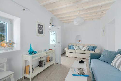a living room with a couch and a table at CORFOS BLUE MYKONOS in Ornos