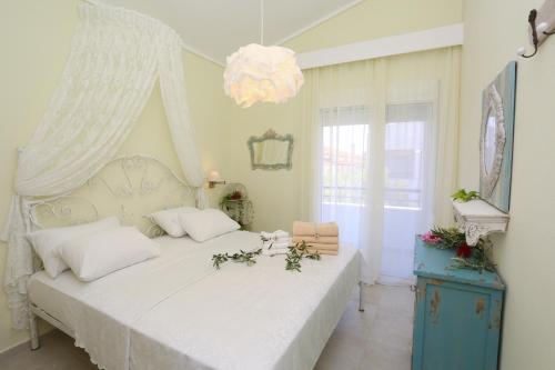 ein Schlafzimmer mit einem weißen Bett und einem Kronleuchter in der Unterkunft Elia in Skála Foúrkas