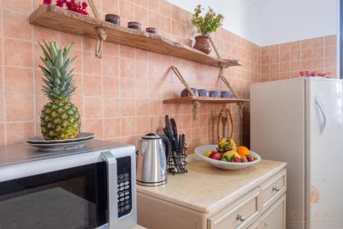 a kitchen with a microwave and a bowl of fruit on a counter at Villa Can Kiko in Dahab
