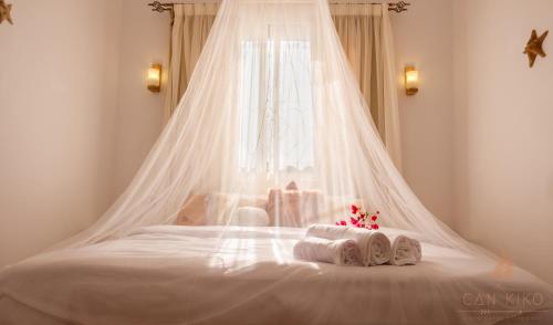 a white bed with a canopy and towels on it at Villa Can Kiko in Dahab
