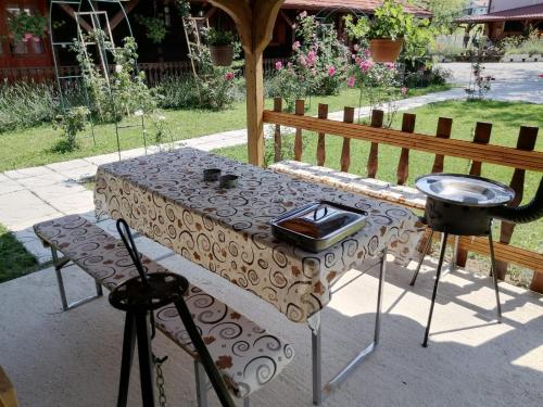 a table with a grill next to a fence at Pod orehom drvena kuća i sauna in Krapina