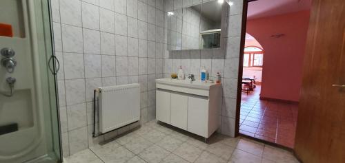 a white bathroom with a sink and a mirror at Vila Vasile in Mamaia Sat/Năvodari