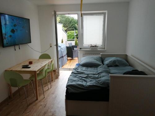 1 dormitorio con 1 cama y 1 mesa con sillas en KIC Kochschule in Colditz Gastroverleih, Mietkoch, HMDL, FEWO en Colditz