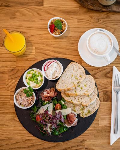 a table with a plate of food with bread and salad at Apartamenty Tespis - Francuska Atal Park in Katowice