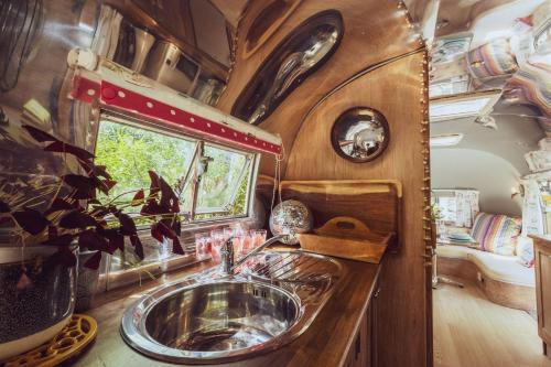 a bathroom with a sink in a travel trailer at Dixie Airstream - Retro 1970s American Airstream close to Windermere in Staveley
