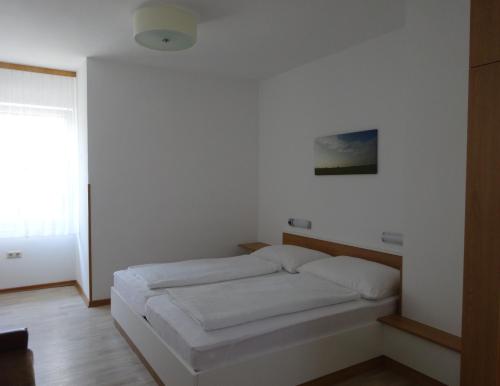 a small bed in a room with a window at Gästehaus Gabriel in Illmitz
