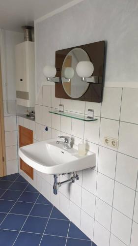 a bathroom with a white sink and a mirror at Ferienwohnung Weinberg in Wesselburener Deichhausen