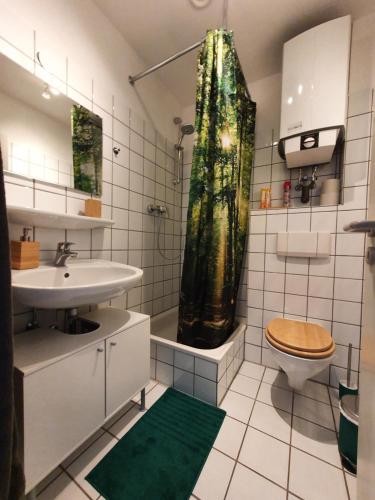 a bathroom with a sink and a toilet and a shower at Zentrales Dachgeschoss-Apartment Bielefeld in Bielefeld