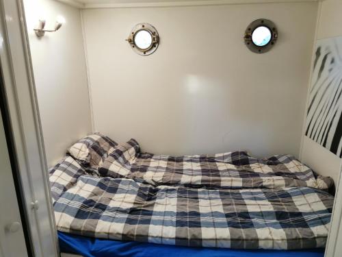 a bed in a room with two mirrors on the wall at loft boat in Amsterdam