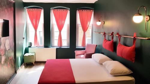 a bedroom with a red and white bed and two windows at Casa Rosa Suites in Istanbul