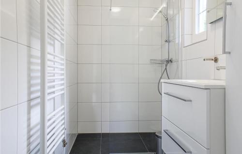 a white bathroom with a shower and a sink at Het Polderhuisje in Strijen