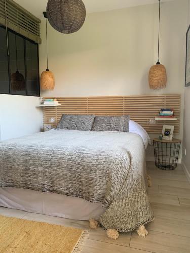 - une chambre avec un lit et deux lampes pendant dans l'établissement La cabane 62, à La Teste-de-Buch