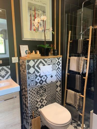 a bathroom with a toilet and a shelf with towels at La cabane 62 in La Teste-de-Buch