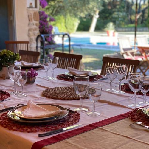 a table with wine glasses and plates on it at Domaine du Commandeur in Mondragon