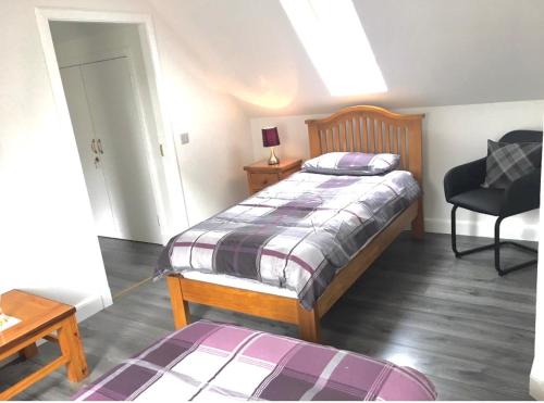 a bedroom with a bed and a desk and a chair at Kilberry Guest House in Beauly