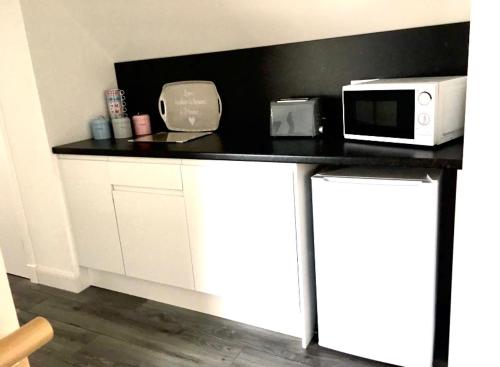 a kitchen with a black counter top with a microwave at Kilberry Guest House in Beauly