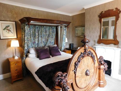 a bedroom with a bed with purple pillows at The Old Registry guest house in Haworth