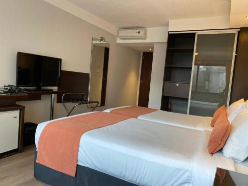a hotel room with a large bed and a television at Crystal Tower in Montevideo