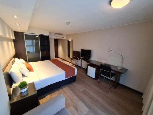 a hotel room with a bed and a desk at Crystal Tower in Montevideo